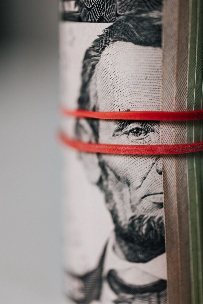 Close-up of a roll of money tied together with a rubber band