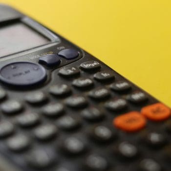 Close up of a calculator against a yellow background