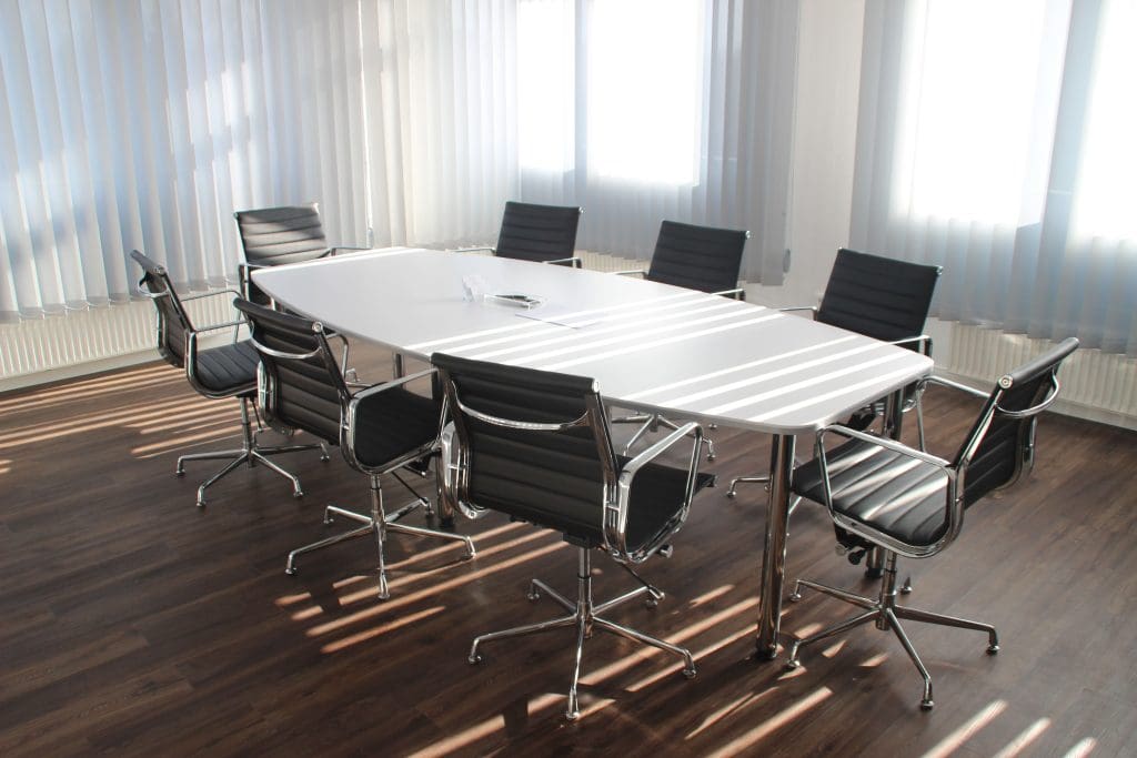 An empty board room meeting space with chairs beside a table