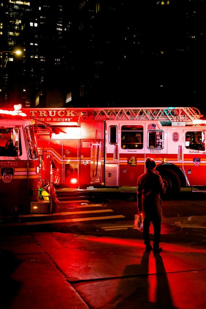 Two firetrucks stopped at an intersection at nighttime