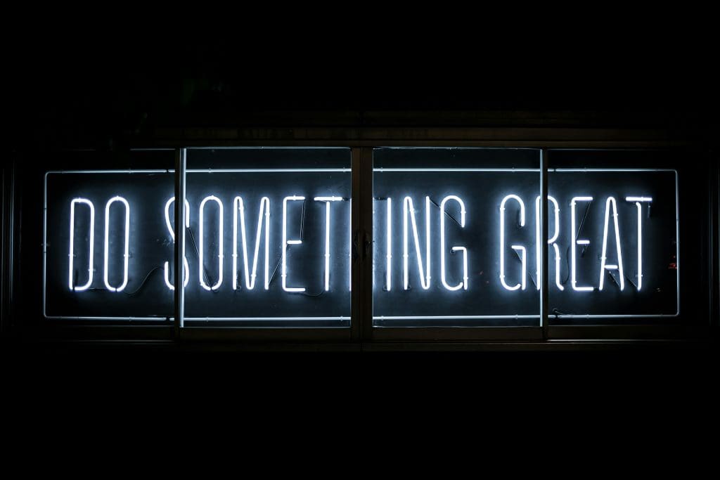 A blue neon sign reading "Do something great"